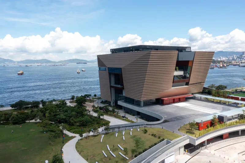 Aerial view of the building complex beside the harbor with ships and mountains beyond