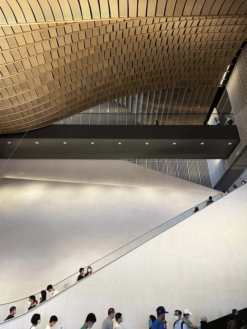 Overhead view of the white sloped wall with visitors ascending the adjacent staircase