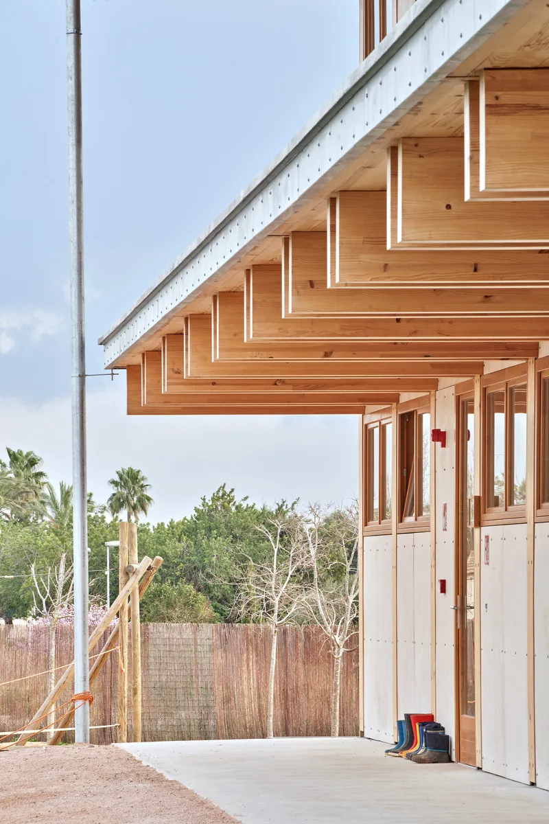 Cantilevered timber eaves with exposed rafters and beams above a covered walkway