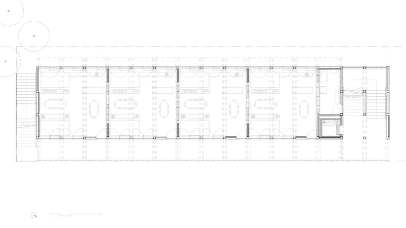 Floor plan drawing of a narrow rectangular building with repeated structural bays and modular rooms