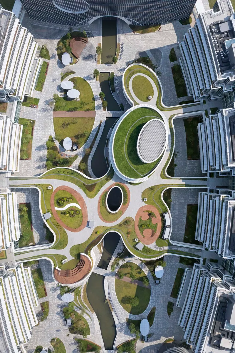 Overhead view of looping planted roof terraces with circular skylights between residential towers