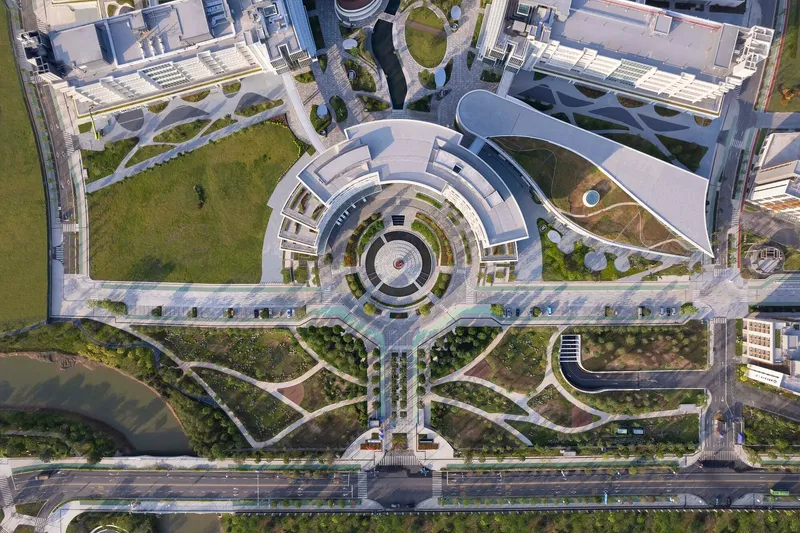 Drone view of circular plaza with concentric pavers leading to pedestrian pathways and green spaces