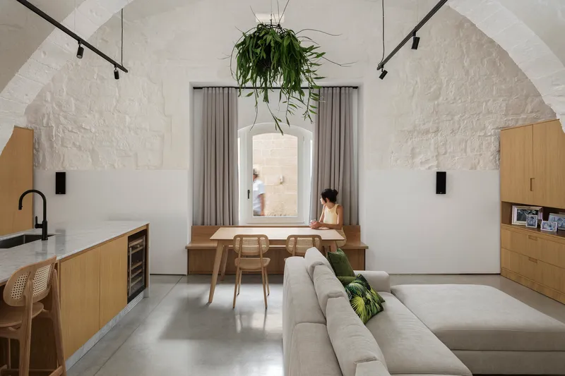 Open living space with hanging planter suspended above a desk positioned in a recessed window alcove