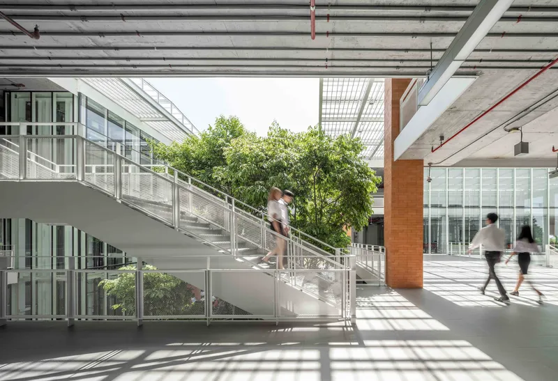 Interior circulation stair with students ascending beneath exposed concrete ceiling and skylights