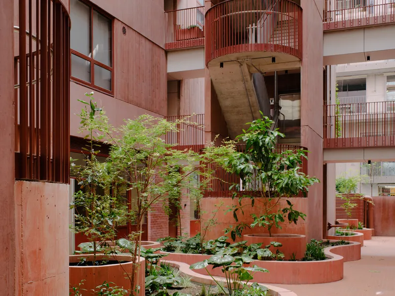 Internal courtyard with curved raised planters and metal screens under residential balconies