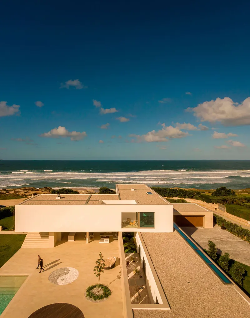 Aerial view of the terraced courtyards and lap pool stretching toward the ocean