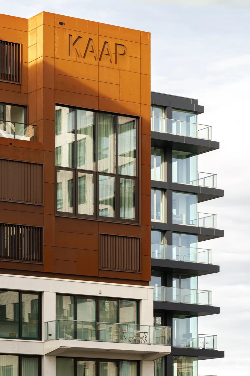 Close-up of the cor-ten steel panel cladding with embossed lettering and vertical slat screens