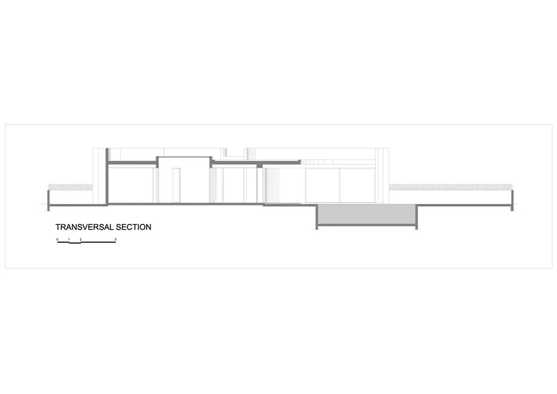 Transversal section drawing showing a single-story structure with a sunken courtyard volume