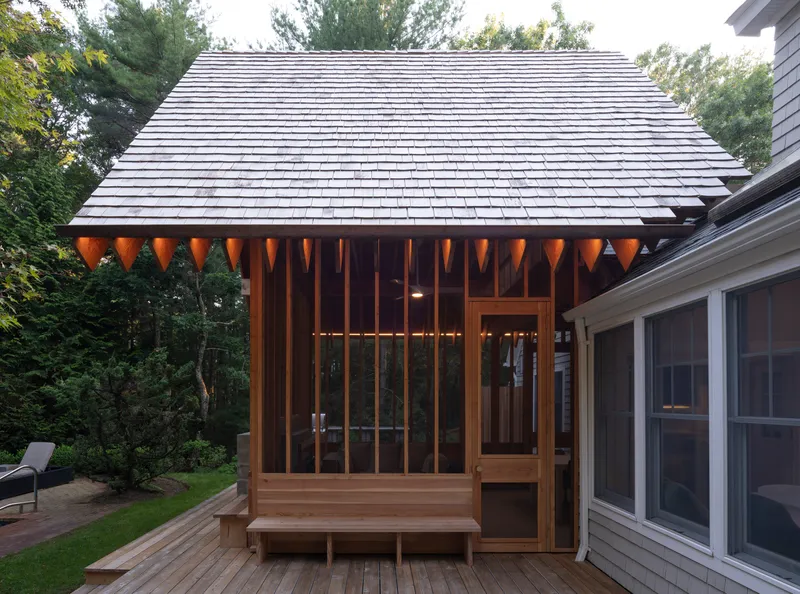 Close-up of the timber pavilion roof eave with exposed rafter tails and vertical wood screen