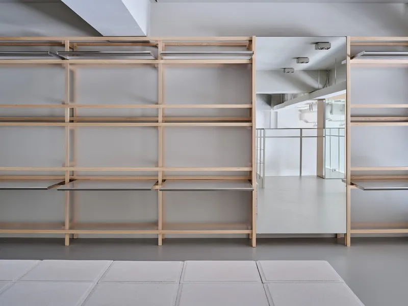 Timber shelving system with frosted glass lower panels along a gray tiled floor