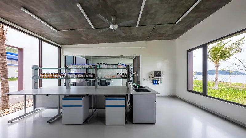 Laboratory interior with stainless steel workbenches and exposed concrete ceiling with ceiling fan
