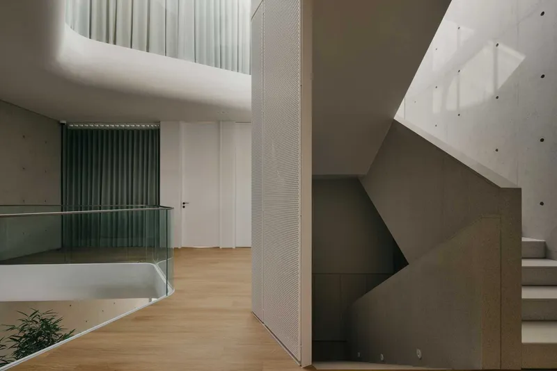 Upper level hallway with perforated metal panels, timber flooring and clerestory skylights above