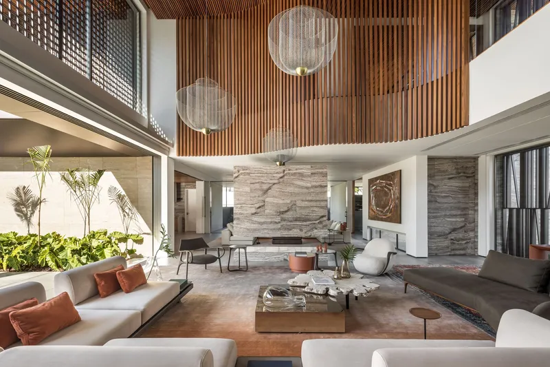 Living room beneath curved timber slat ceiling with spherical pendant lights suspended above
