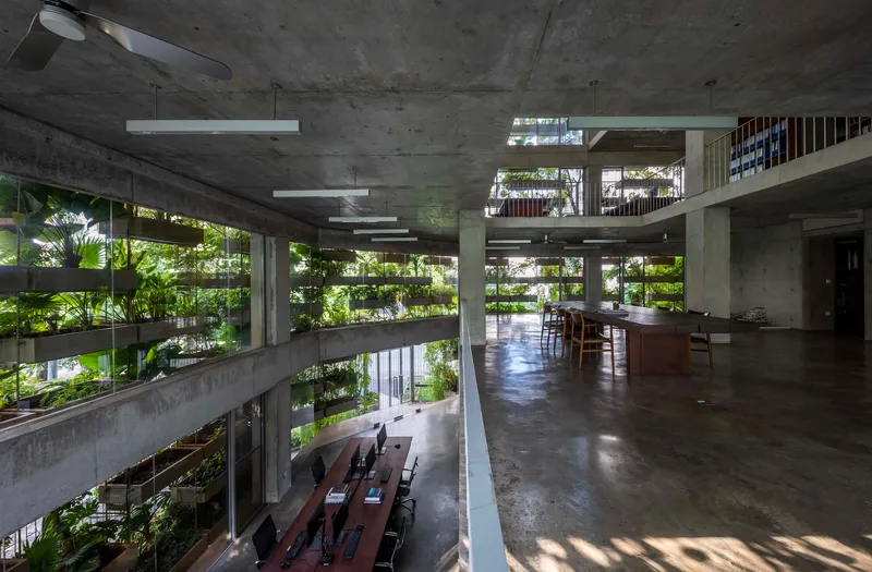 Upper floor workspace with polished concrete floor and views to planted terraces and lower level