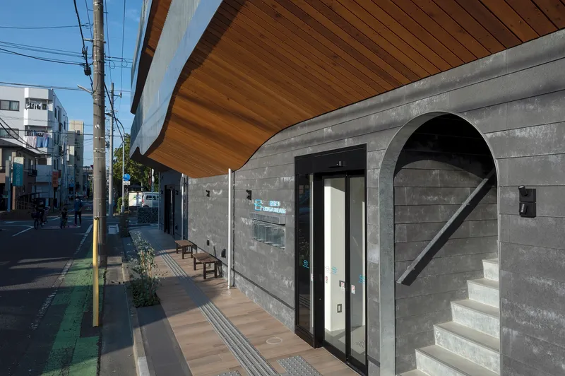 Street level entrance with concrete block wall, arched opening with stair, and overhanging wood soffit