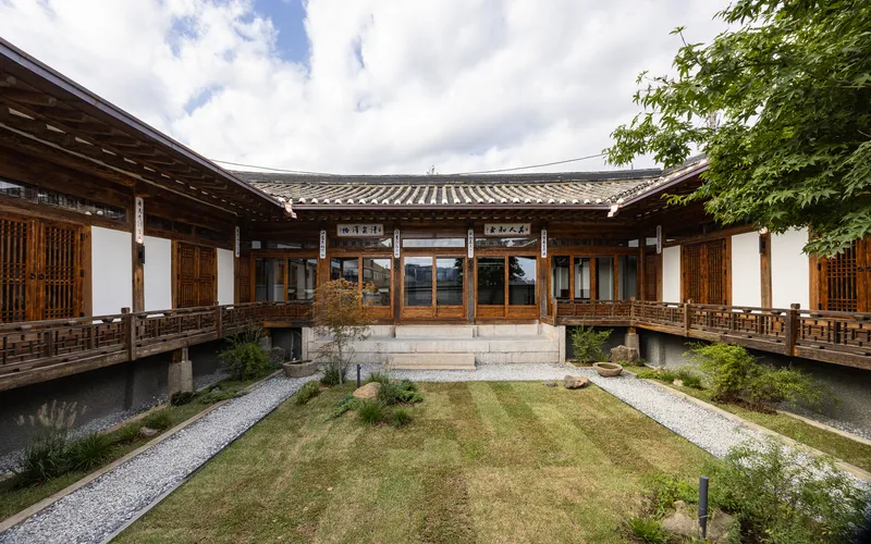 Courtyard framed by elevated timber verandas with lattice screens and planted garden beds below