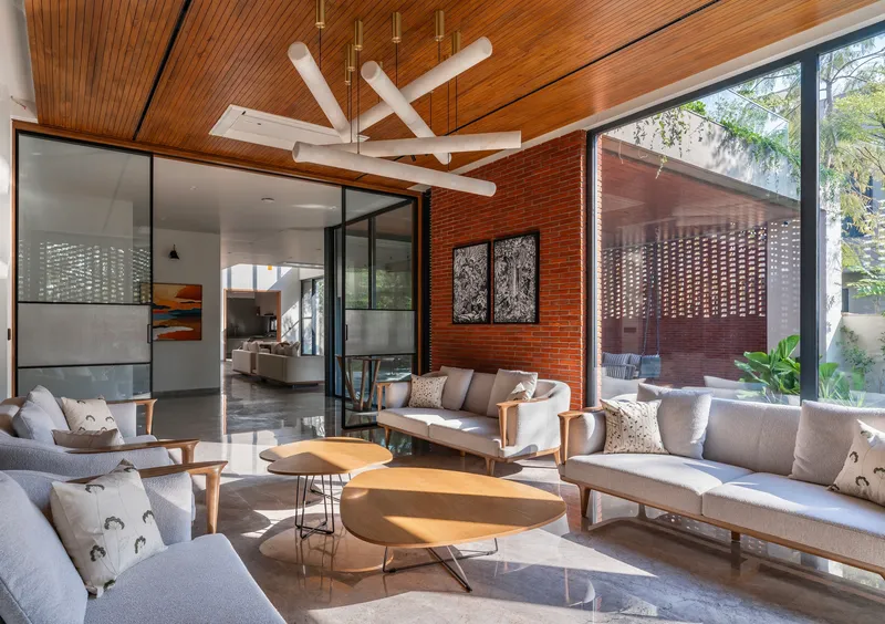 Seating area with sculptural white ceiling fixture beneath timber slats and warm afternoon sunlight