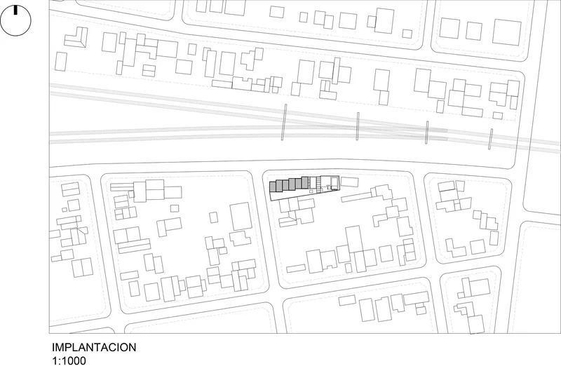 Site plan drawing showing building footprints within urban blocks bisected by a rail corridor