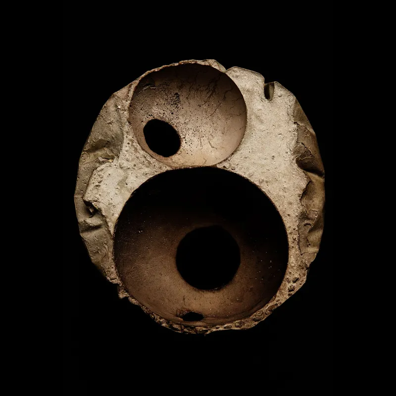 Top view of a circular concrete block with three interlocking voids forming curved chambers