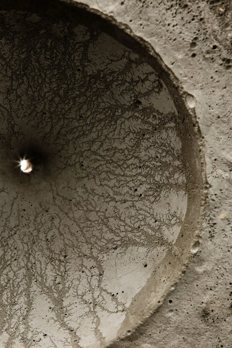 Interior view looking up into one of the curved concrete voids with textured surface