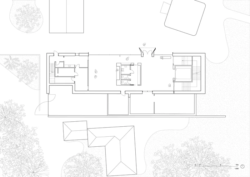 Floor plan drawing showing linear building with interior courtyard and surrounding landscape elements