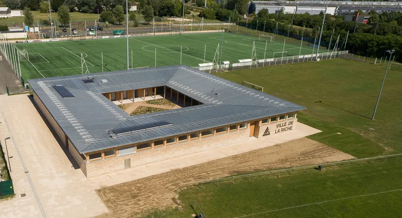 Aerial view of the square plan with dark standing-seam metal roof enclosing a central courtyard