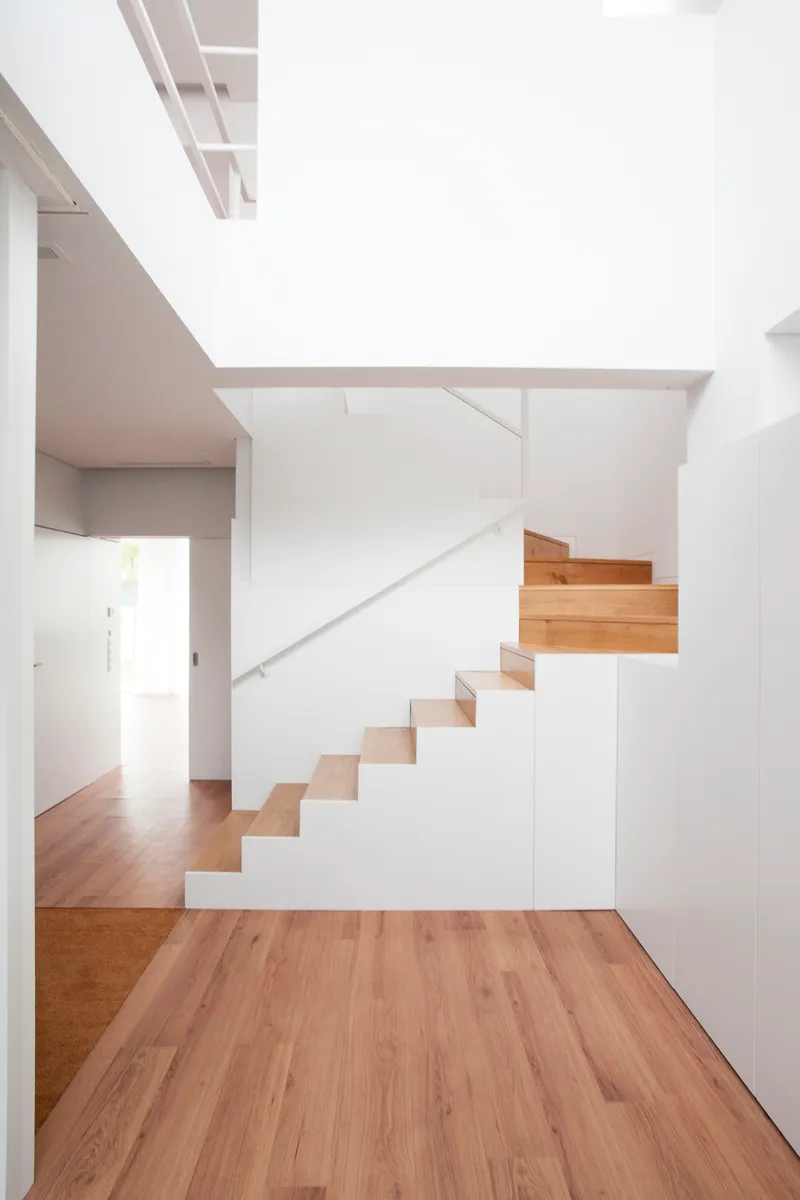 Timber and white staircase with integrated storage beneath the treads and skylight above