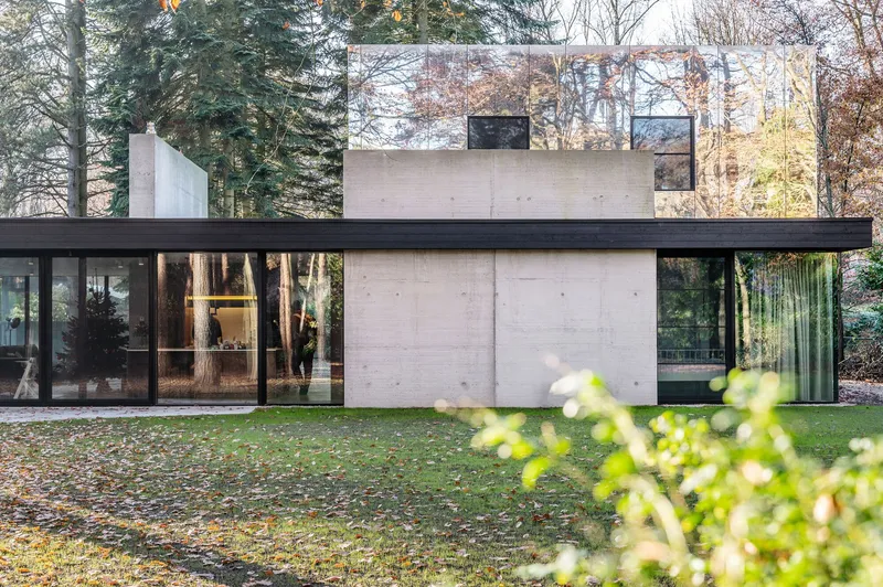 Garden facade showing stacked concrete volumes with dark horizontal banding and floor-to-ceiling glazing