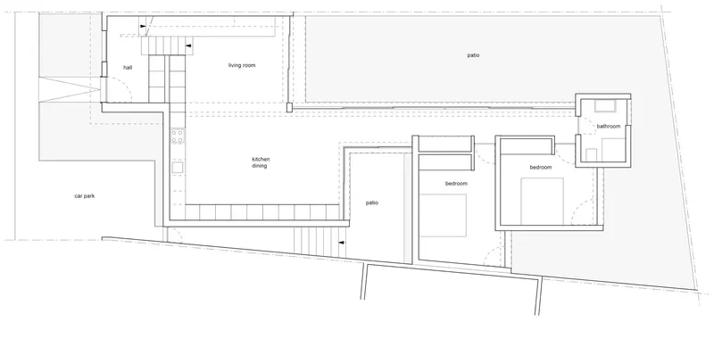 Floor plan showing living spaces arranged around two patio areas with adjacent car park