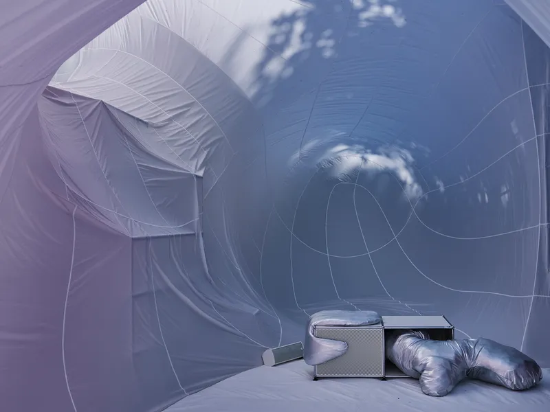 Interior view of the pale inflatable fabric with circular openings and clouds reflected on the surface