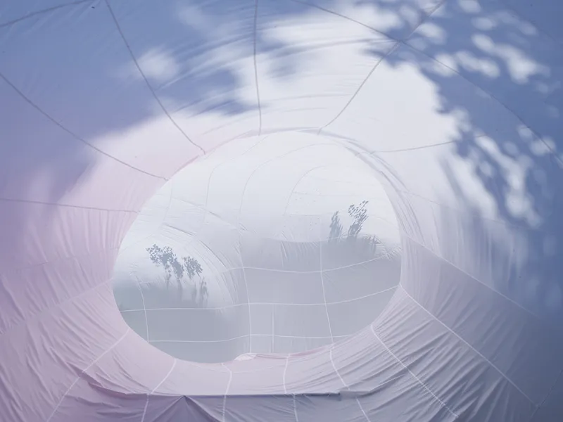 Translucent inflatable tunnels connecting spherical volumes with dappled shadows cast across the surfaces
