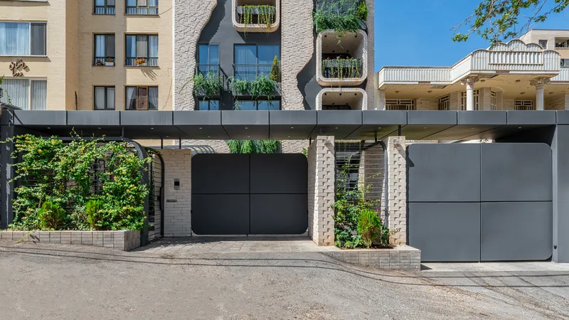 Ground-level entrance gate with dark metal panels and textured brick columns