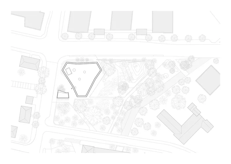 Site plan drawing showing pentagonal footprint within a landscaped campus and adjacent buildings