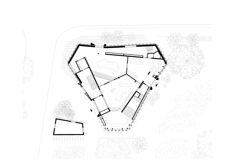 Site plan drawing showing a pentagonal building footprint with surrounding landscape and trees