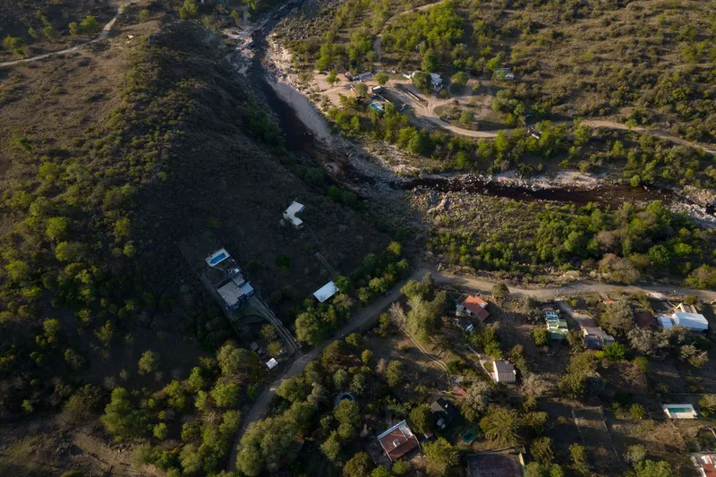 Drone view of clustered buildings within wooded landscape at golden hour