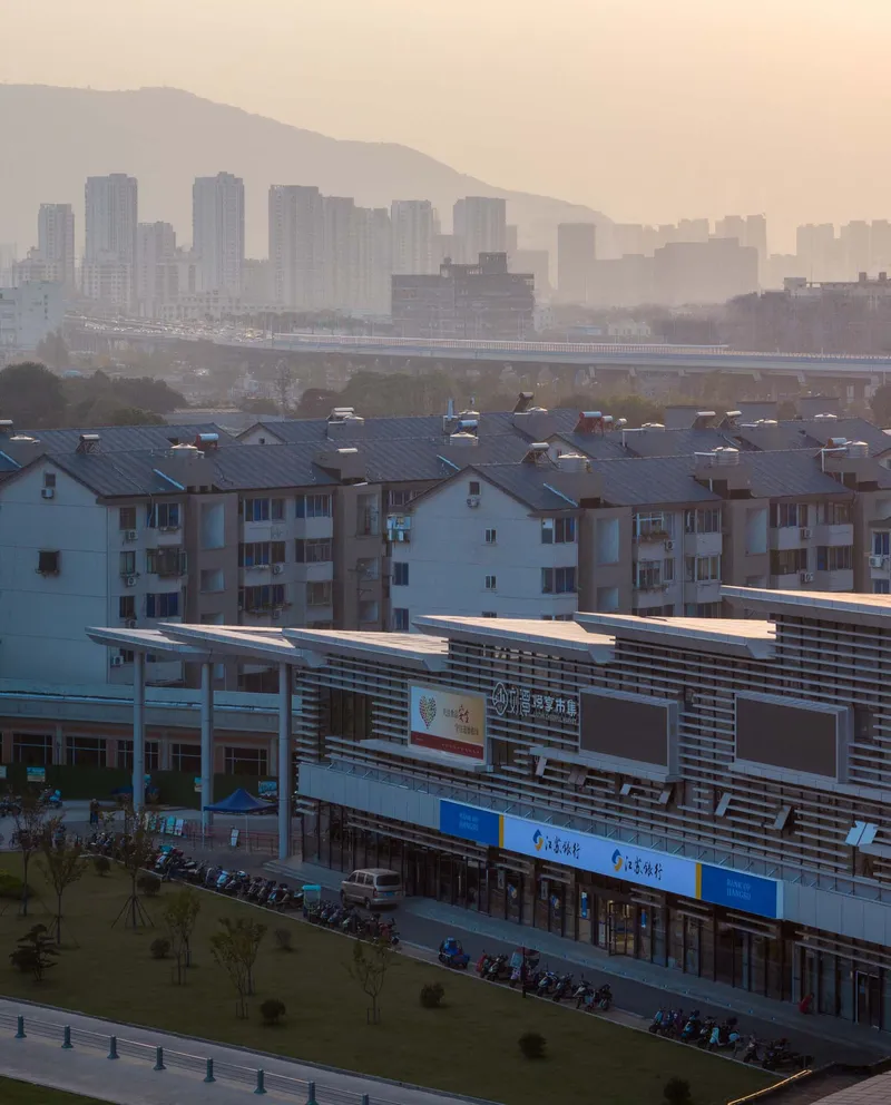 Distant view of the horizontal louvered facade with mountains and hazy skyline at dawn