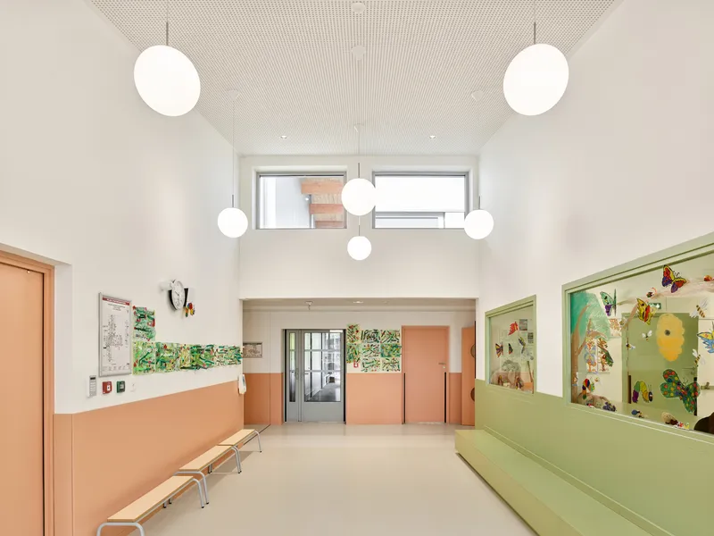 Lobby with clerestory windows, globe pendant lights, and peach and green painted wall panels