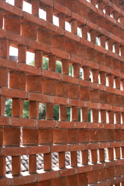 The image showcases a brickwork screen facade, featuring an openwork pattern that allows light and a