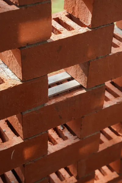 This architectural image showcases a stack of red bricks, highlighting their texture and pattern. Th