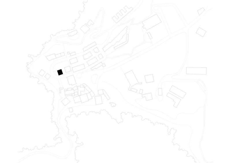 Site plan drawing showing a single building footprint highlighted in black within a hillside village layout
