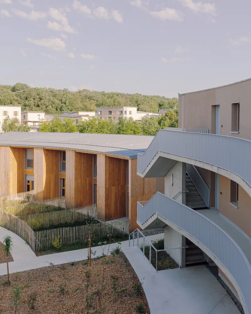 Aerial view of the curved courtyard with timber frames, metal roofing and planted landscape beds