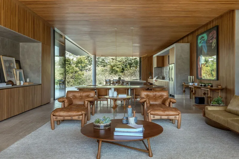 Central living space with timber ceiling canopy and concrete walls framing kitchen and outdoor terraces