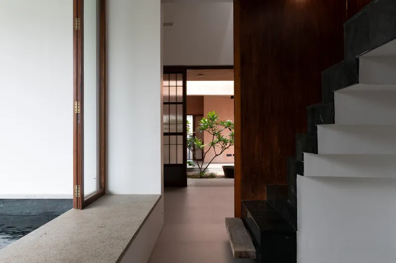Interior passage with timber door frames and grey stone steps leading to an upper level
