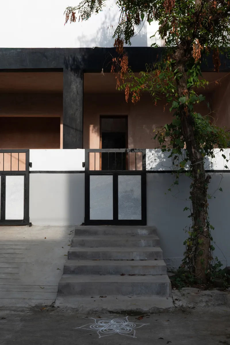 Street entrance with concrete steps and metal gate beneath a tree at dusk