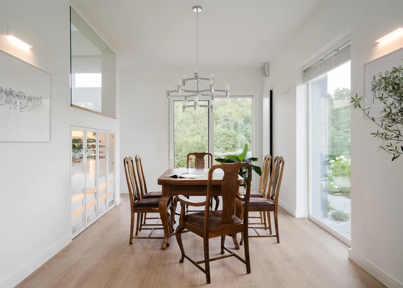 Dining area with glass pendant and floor-to-ceiling windows overlooking the garden