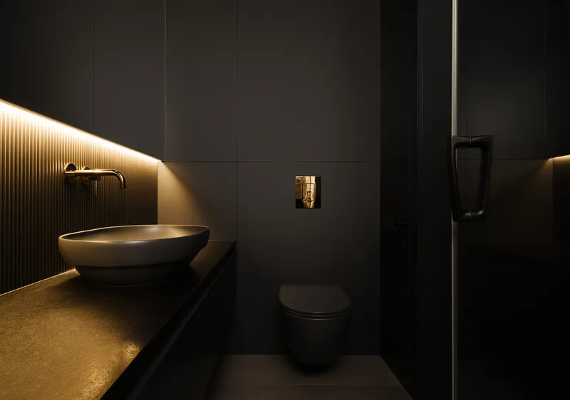 Bathroom with fluted black wall panels, integrated strip lighting, and oval vessel sink on cantilevered counter