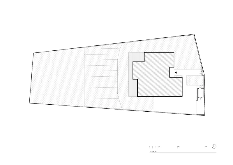 Site plan drawing showing the footprint of two connected volumes on a sloped rectangular lot