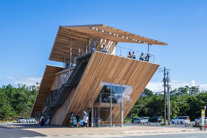 Exterior view of the cantilevered timber tower with exterior staircase and rooftop observation deck under blue sky