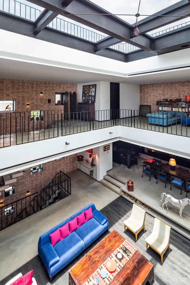 View across the central atrium showing stacked galleries with steel railings and skylight above