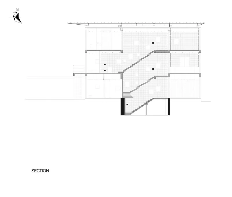 Section drawing showing a multi-flight staircase rising through three levels beneath a sloped roof